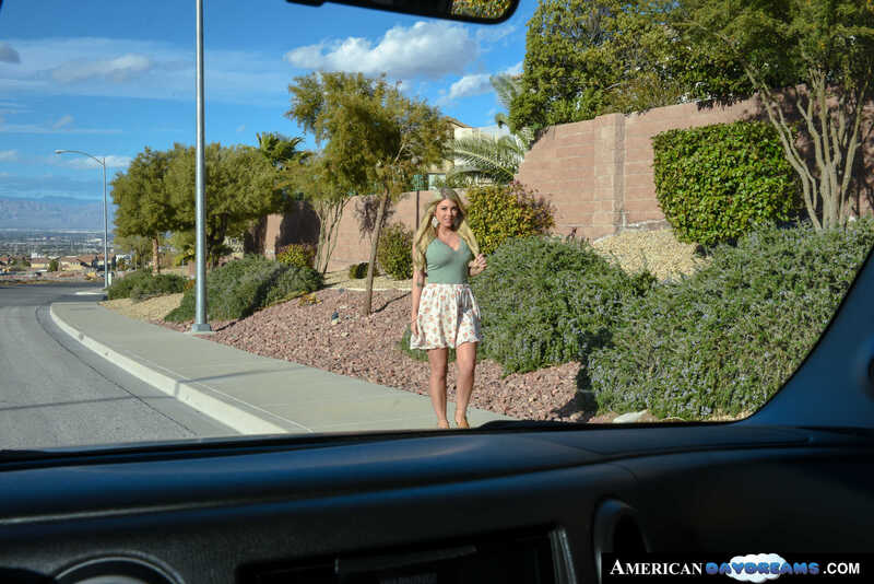 Scene from Naughty America Kayla Kayden porn video 'Hitchhiking babe, Kayla Kayden, reciprocates your good deed with some dick sucking and wet pussy' where Kayla Kayden is standing outside of a car.