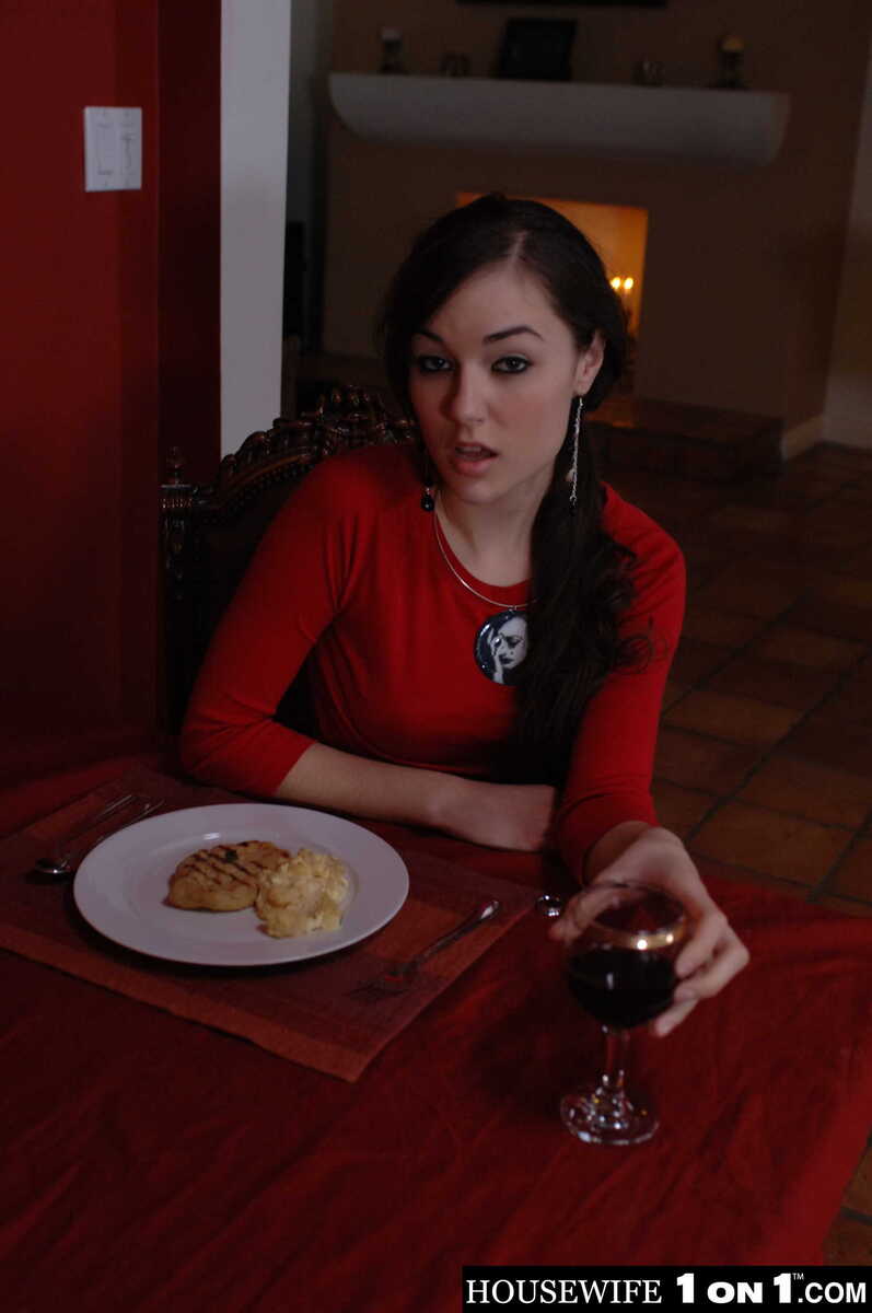 Scene from Naughty America Sasha Grey porn video 'Sasha Grey fucks her husband' where Sasha Grey is eating breakfast in a red shirt.