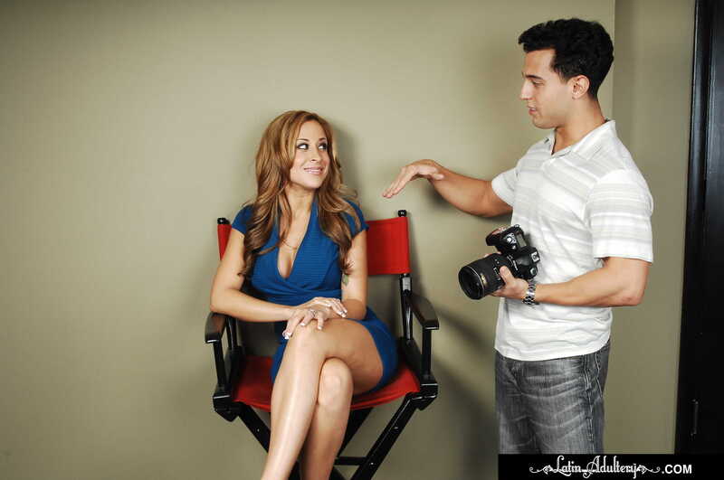 Naughty America August porn: August o Alvarez is pointing at the woman in the chair.