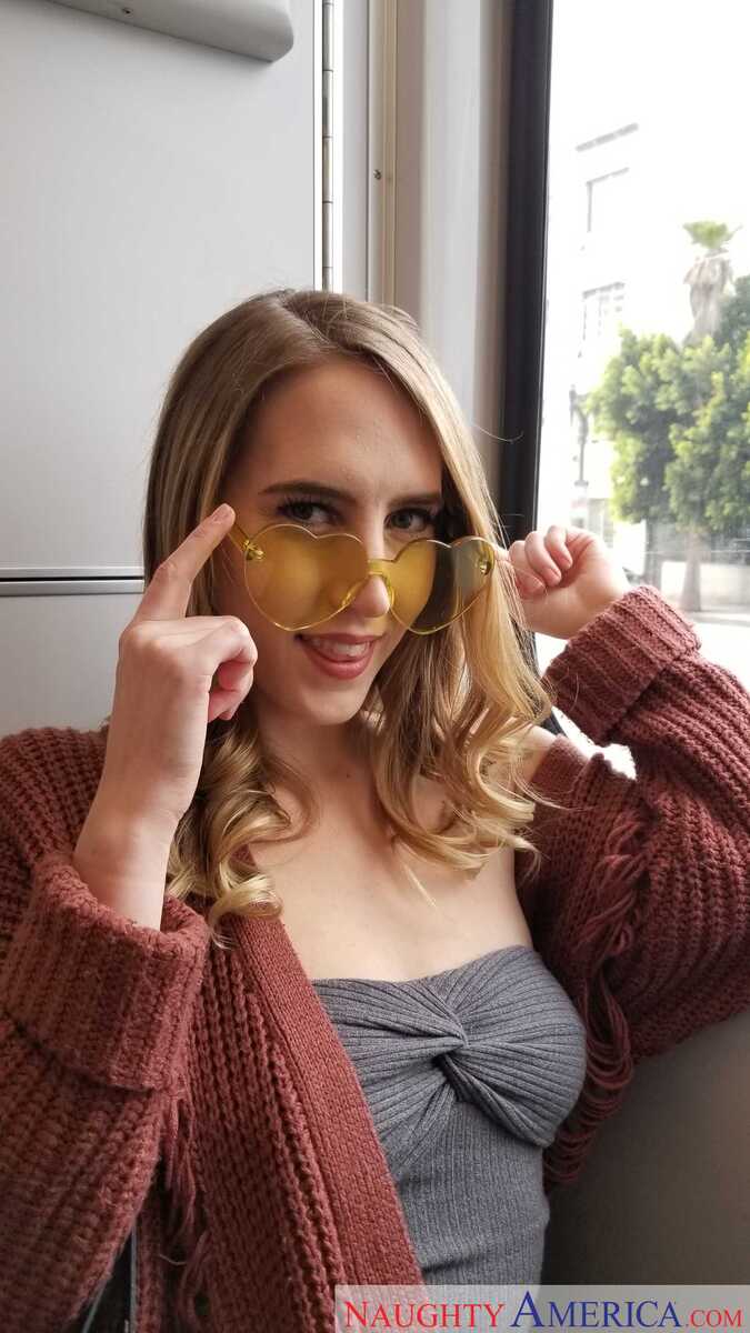 Naughty America Cadence Lux porn: Cadence Lux is wearing a brown sweater and gold sunglasses.