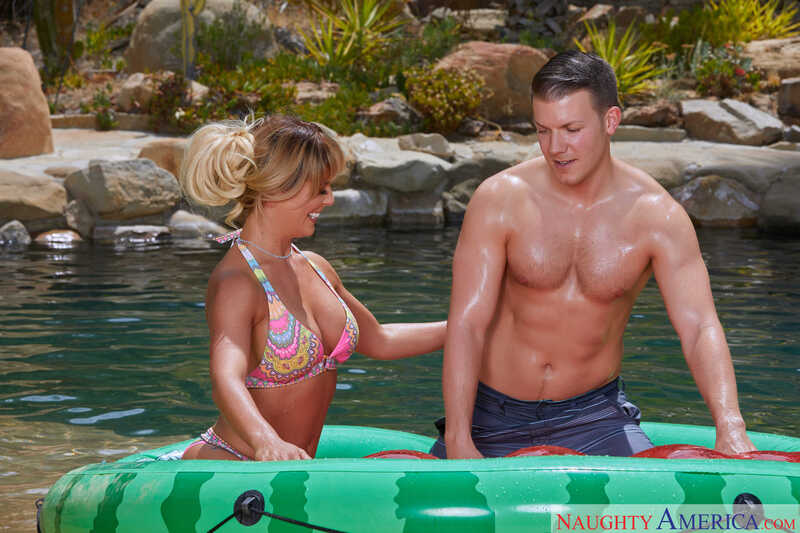 In the Cherie DeVille Naughty America porn scene 'A MILF on a Hot Summer’s Day: Cherie DeVille' from My Friend's Hot Mom, Cherie DeVille and a man are in a raft in the water.