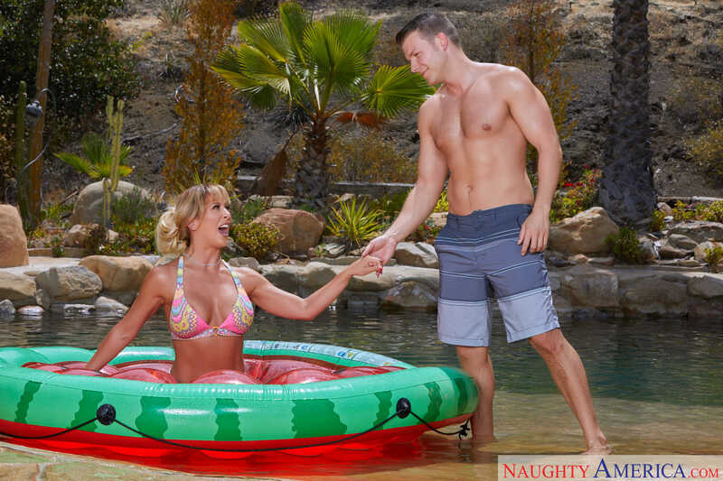 Naughty America Cherie DeVille porn: Cherie DeVille is in a bikini in a raft in the water.