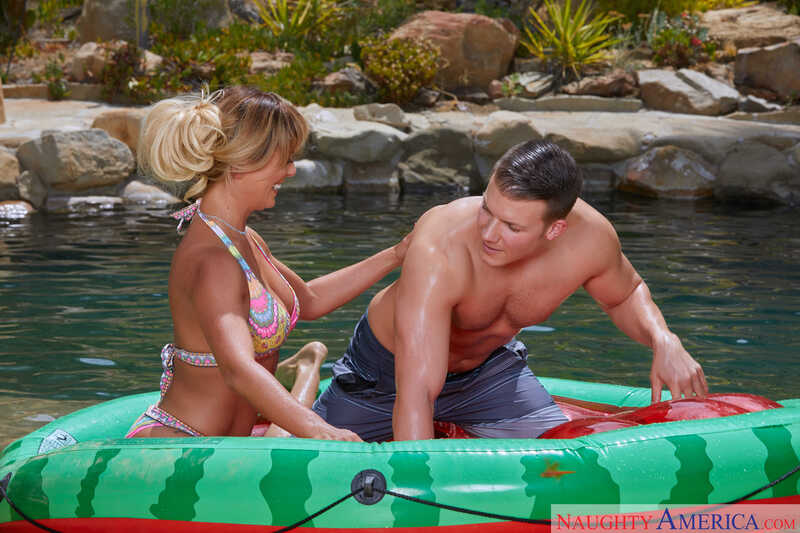 Scene from Naughty America Cherie DeVille porn video 'A MILF on a Hot Summer’s Day: Cherie DeVille' where Cherie DeVille and her man are in a raft in the water.