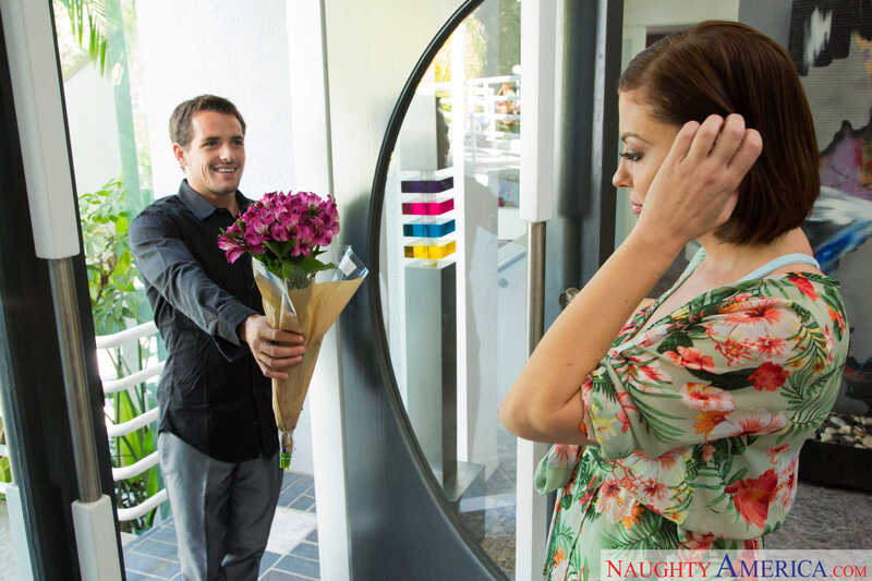 Scene from Naughty America Sovereign Syre porn video 'Sovereign Syre Lends Her Pussy To Her Son's Friend' where Sovereign Syre is the name of the man holding the flowers.