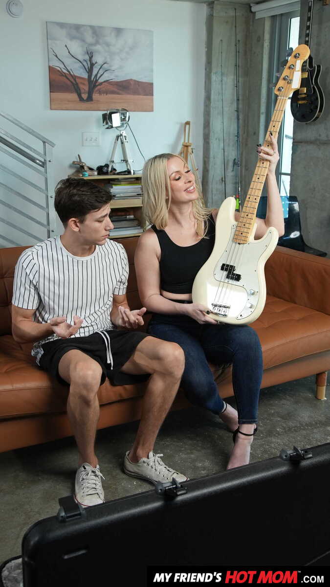 My Friend's Hot Mom Sydney Paige porn scene 'Blonde MILF Sydney Paige teaches son's friend how to finger his bass guitar... and her pussy' - Sydney Paige and her friend are holding a guitar.