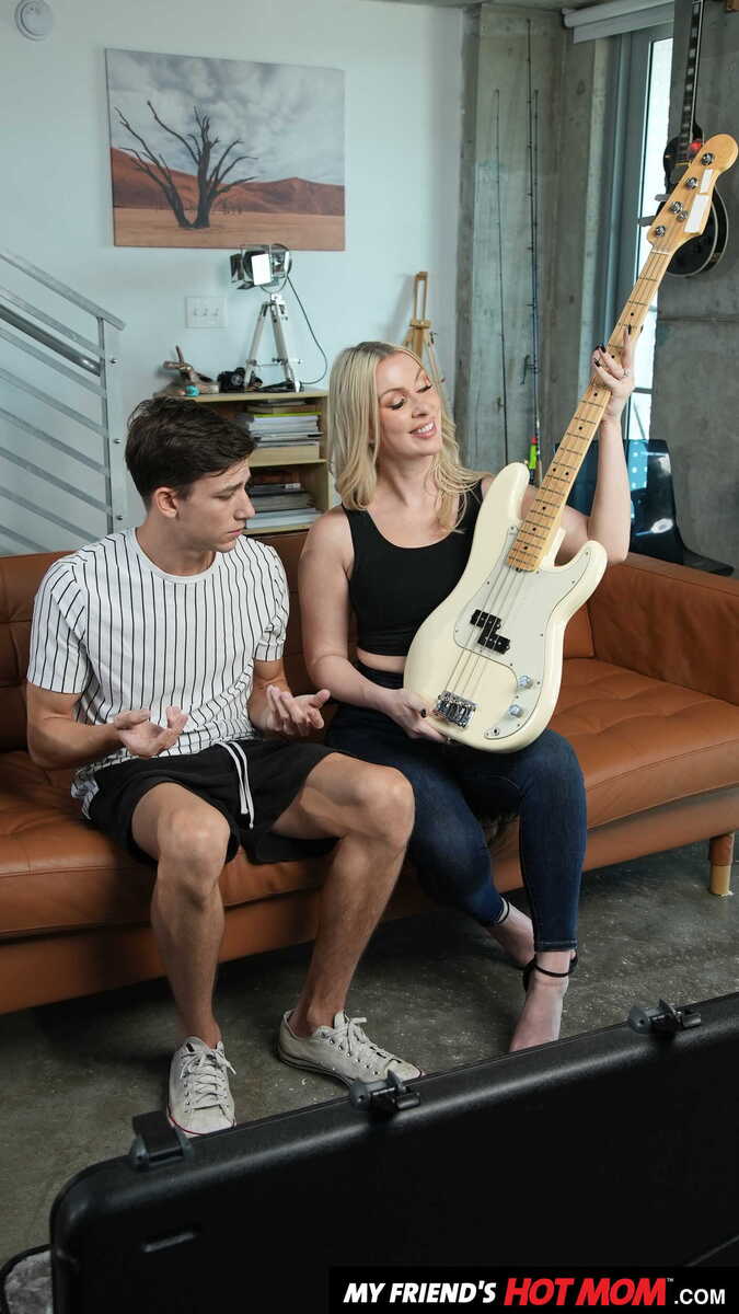 Scene from Naughty America Sydney Paige porn video 'Blonde MILF Sydney Paige teaches son's friend how to finger his bass guitar... and her pussy' where Sydney Paige and her friend are playing guitars together.