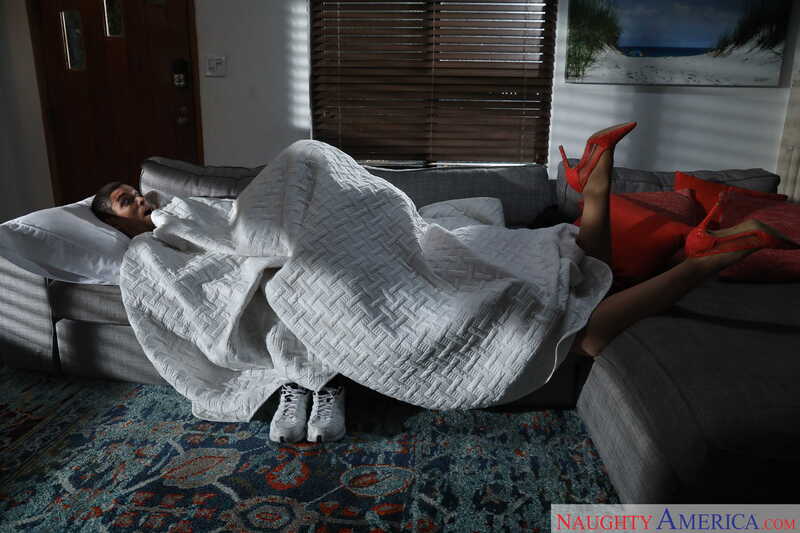 In the Yasmin Scott My Friend's Hot Mom porn scene 'Yasmin Scott fucking in the living room with her bubble butt', Yasmin Scott is laying on a couch with a blanket over her.