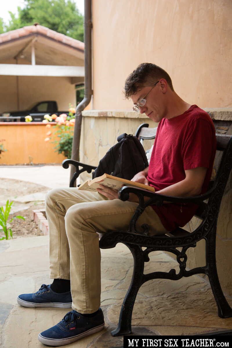 Scene from Naughty America Kenzie Taylor porn video 'Professor McKenna fucks student after class' where Kenzie Taylor is reading a book on a bench.