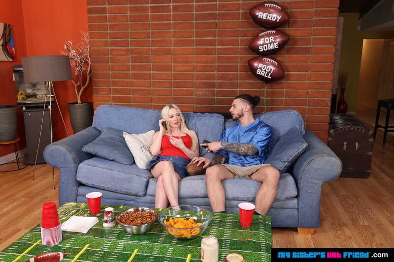 Scene from Naughty America Naomi Ryder porn video 'Naomi Ryder Gets turned on with football players in gear' where Naomi Ryder and her boyfriend are on a couch with footballs.