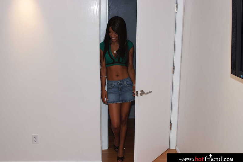 My Wife's Hot Friend Riyanna Skie porn scene 'Riyanna Skie takes friends husbands big  cock' - Riyanna Skie is standing in a doorway wearing a green crop top and a jean skirt.