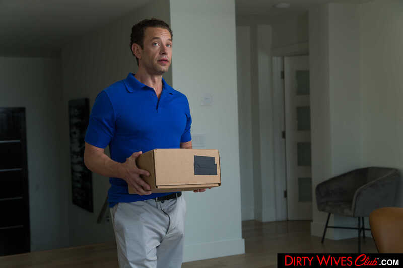 Dirty Wives Club Kayley Gunner porn scene 'Sexy blonde bombshell Kayley Gunner fucks delivery man with husband's permission' - Kayley Gunner is holding a box in her hands.