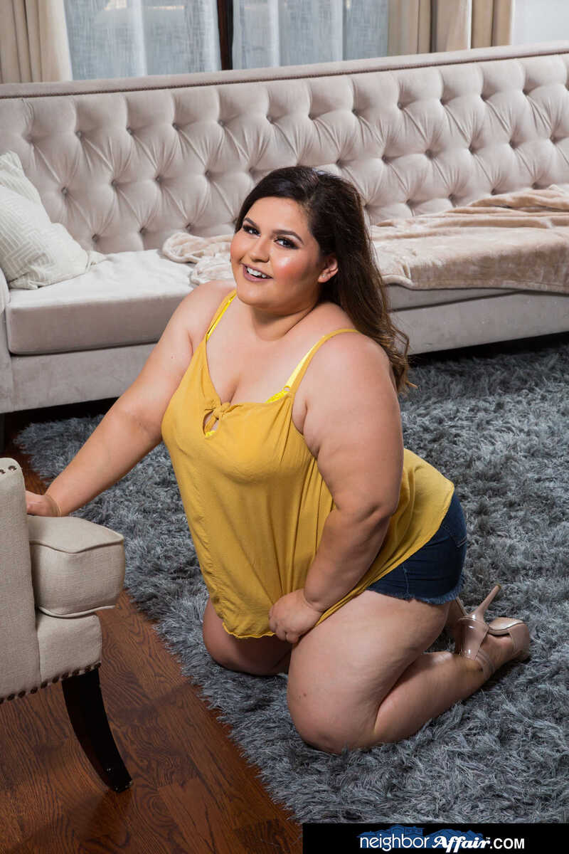 In the Karla Lane Naughty America porn scene 'Karla Lane consoles her neighbor with her wet pussy' from Neighbor Affair, Karla Lane is a plus size model who is kneeling on a rug.