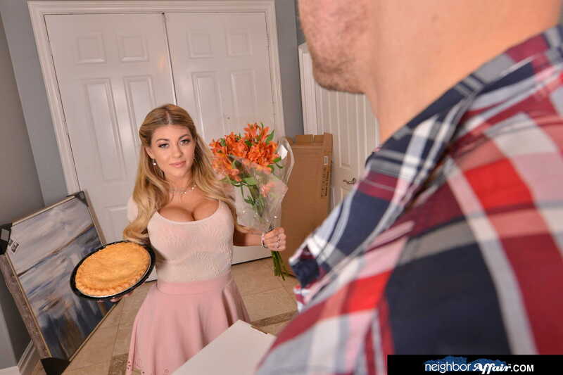 In the Kayla Kayden Neighbor Affair porn scene 'Kayla Kayden wants to fuck you as a welcome to the neighborhood', Kayla Kayden is holding a pie and flowers in her hand.