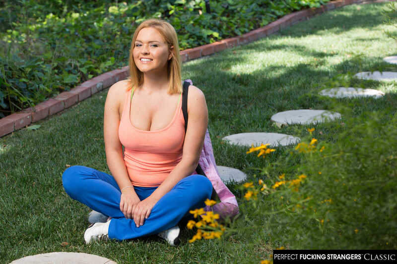 Scene from Naughty America Krissy Lynn porn video 'Krissy Lynn gets her wet pussy fucked by a stranger' where Krissy Lynn is sitting on the grass in a tank top and blue pants.