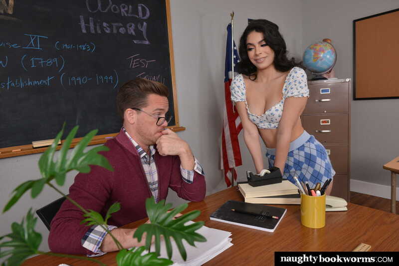 In the Angel Gostosa Naughty Bookworms porn scene 'Brazilian school girl Angel Gostosa takes a ride on her professor's big cock', Angel Gostosa is bending over a man in a classroom.