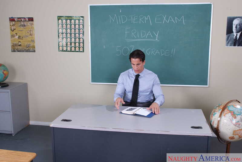 Naughty America Faye Reagan porn: Faye Reagan is a teacher in a classroom with a chalkboard behind her.